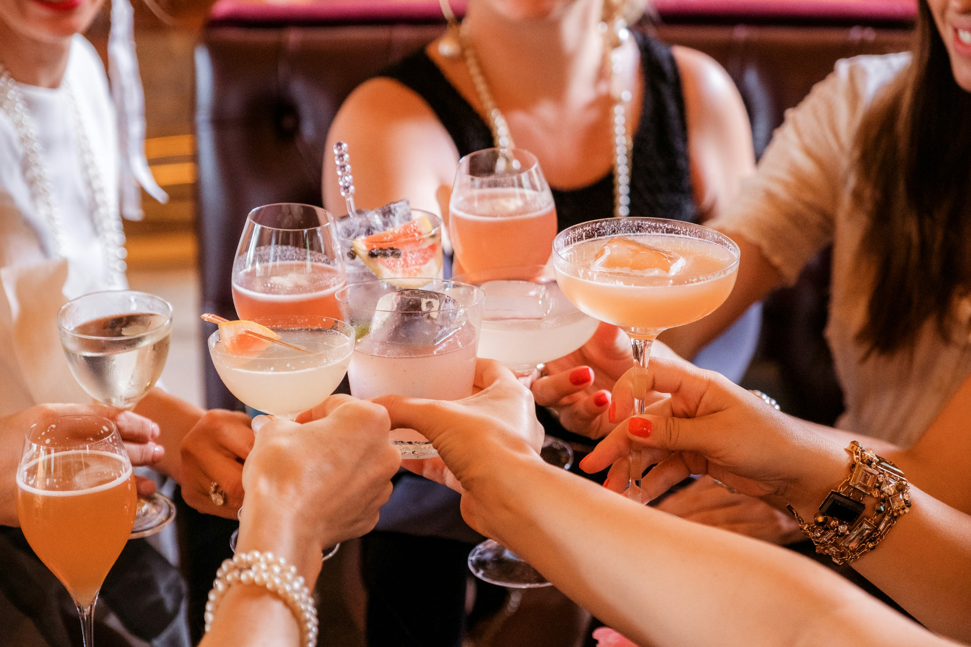 Friends raising cocktails and wine glasses in a toast