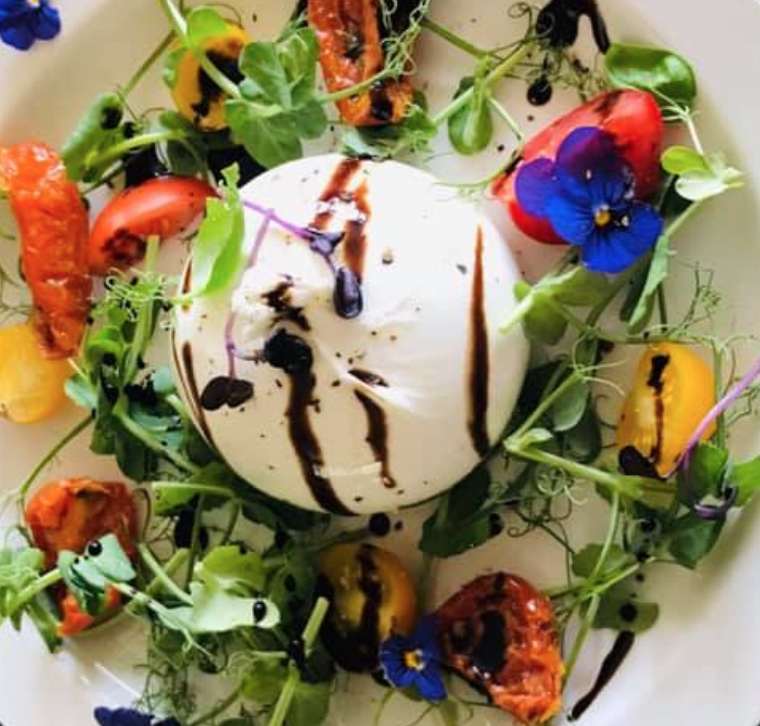 Burrata salad with tomatoes and edible flowers