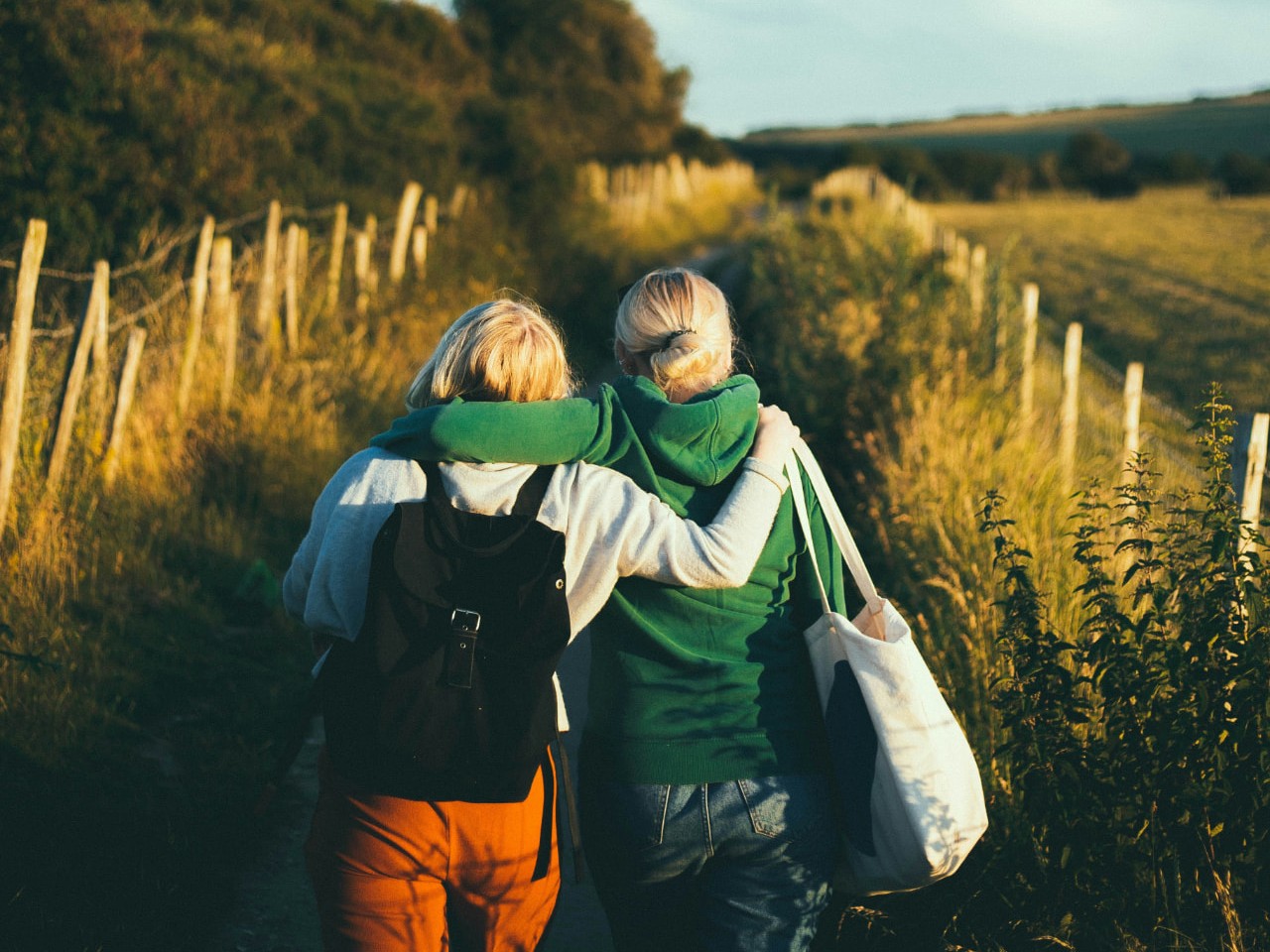 Two friends walking arm in arm along a Somerset footpath