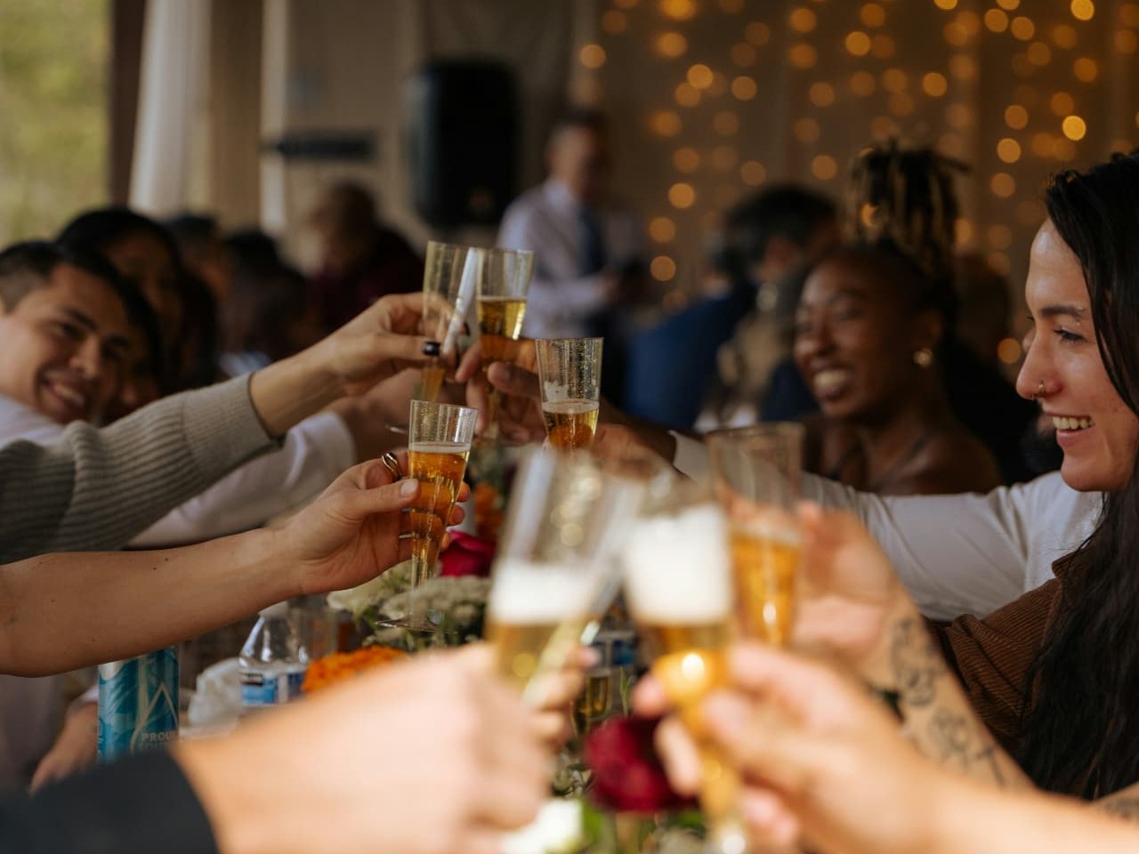 Guests raising champagne flutes in a toast around a decorated table